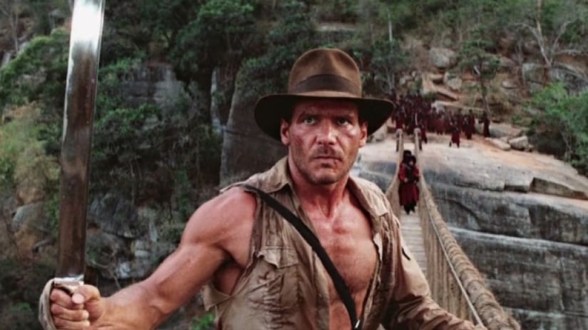 Indiana jones standing on a bridge in the temple of doom