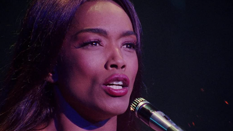 Angela Bassett Starring as Tina Turner , singing into microphone