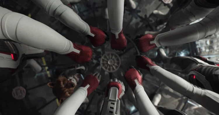 The Avengers gathering their hands together, ready to begin a dangerous time travel mission