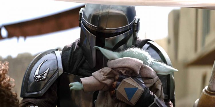 Din Djarin, The Mandalorian, holding baby Grogu.