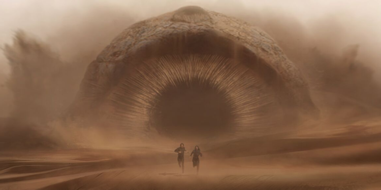 two people chased through the desert by a giant worm