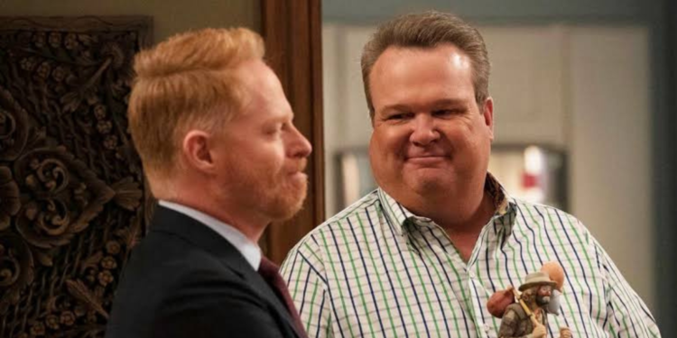 Eric Stonestreet looking to Jesse Tyler Ferguson in a suit.