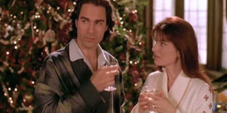  Eric McCormack and Roma Downey standing in front of a christmas tree.
