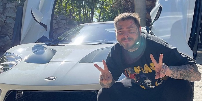 Post Malone posing with a Car