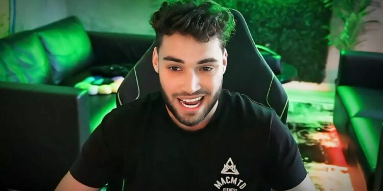 Adin Ross smiling with green background