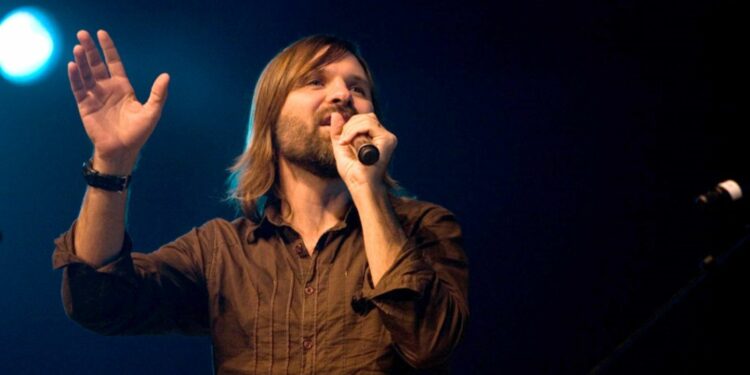 Famous singer Mac powell holding a mic