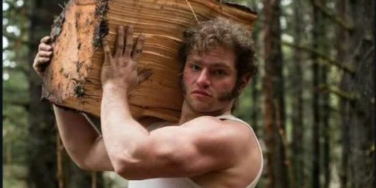 Gabriel Brown carrying a log on his shoulder