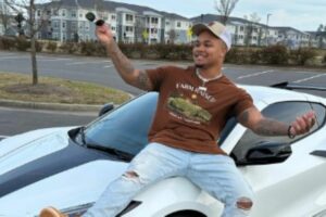 Suave Xavier posing on his luxury car