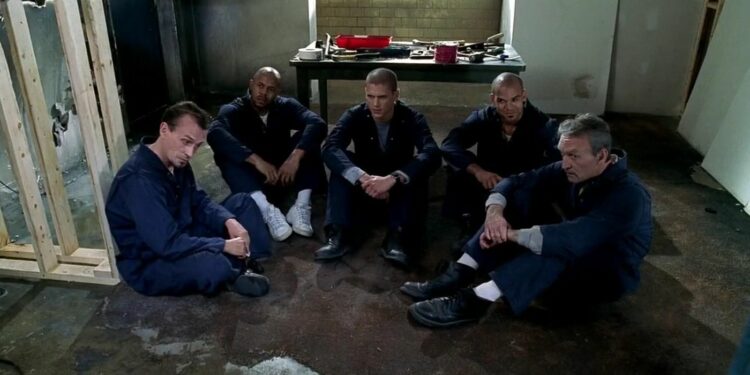 a group of prisoners sitting on ground