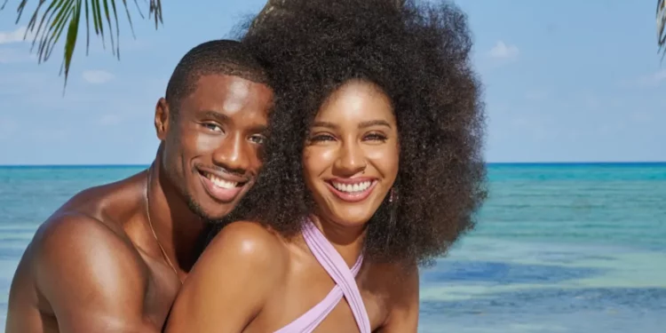 Christine Obanor and Nigel Jones in front of a ocean posing for a photo