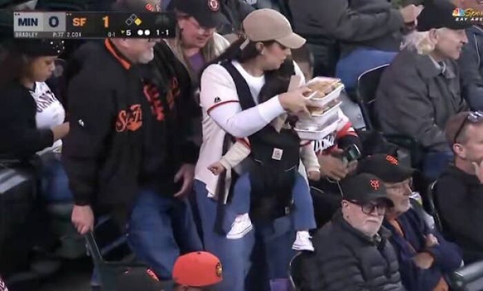 Giants Camera Catches Mom Doing Double Duty With A Baby And Food, Her Husband Just Gets Comfy Giants Camera Catches Mom Doing Double Duty With A Baby And Food, Her Husband Just Gets Comfy