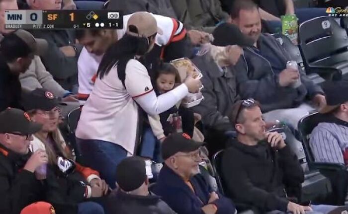 Giants Camera Catches Mom Doing Double Duty With A Baby And Food, Her Husband Just Gets Comfy Giants Camera Catches Mom Doing Double Duty With A Baby And Food, Her Husband Just Gets Comfy