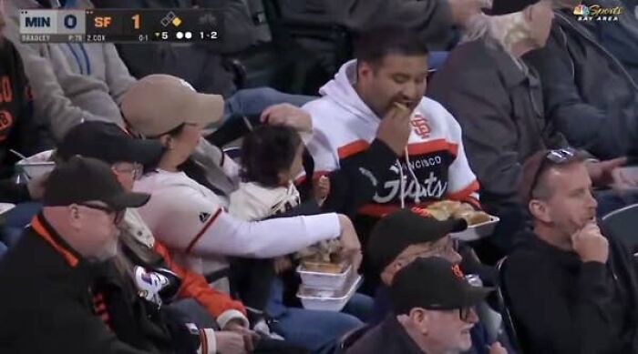 Giants Camera Catches Mom Doing Double Duty With A Baby And Food, Her Husband Just Gets Comfy Giants Camera Catches Mom Doing Double Duty With A Baby And Food, Her Husband Just Gets Comfy